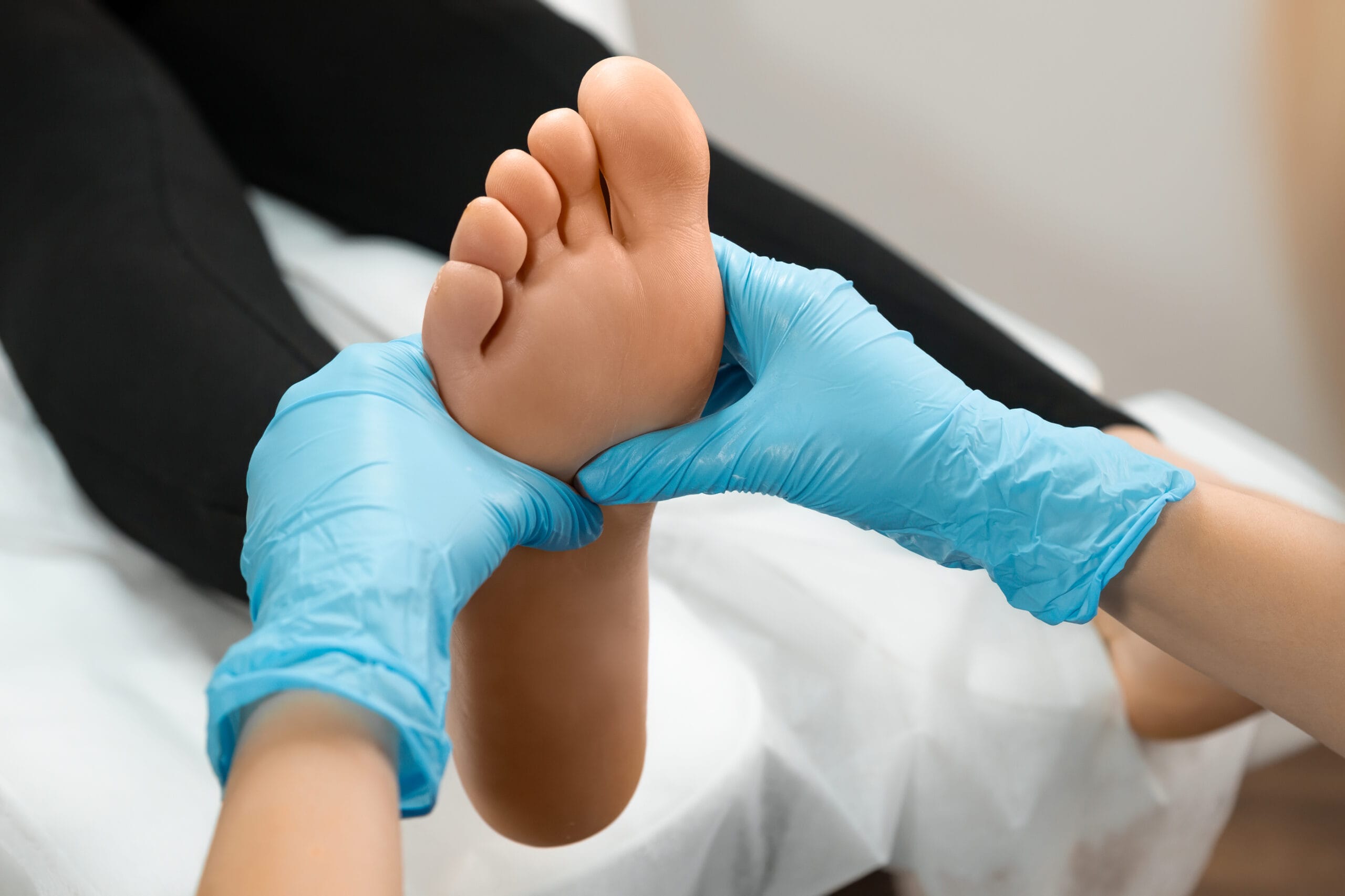 Close up of therapist or podiatrist hands massaging female foot.